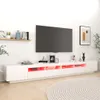A modern white TV stand with LED lighting, a large television, and decorative items. Náhled obrázku produktu