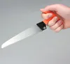 A hand holding a small saw with an orange handle. Náhled obrázku produktu