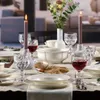 A beautifully set dining table with plates, glasses, bread, and candles. Náhľad obrázku produktu