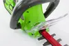 Close-up view of the handle and blade guard of a green hedge trimmer. Podgląd zdjęcia produktu