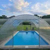 An outdoor swimming pool covered by a transparent enclosure. Produktbild-Vorschau