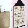 An advent calendar hanging on a pink door next to a woven bag on a white wall. Podgląd zdjęcia produktu