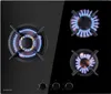 A top-down view of a black gas cooktop with three burners, two of which are lit with blue and orange flames. Podgląd zdjęcia produktu