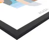 A close-up view of the corner of a framed picture with a black frame. Produktbild-Vorschau