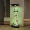 A tall, narrow glass display cabinet with black accents and internal lighting, showcasing several collectible figurines. Produktbild-Vorschau