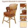 A brown toddler booster seat attached to a wooden chair, with close-up images highlighting its features. Produktbild-Vorschau