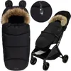 A black stroller footmuff with a fur-lined hood and ears, shown both on its own and installed in a stroller. Náhled obrázku produktu