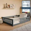 A child's bed with protective rails in a room setting, with decorative items on a shelf above.