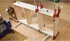 A person is assembling a wooden shelving unit using clamps. Voir les images du produit