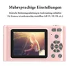 A pink digital camera with a picture of a woman on the screen, with German text above. Podgląd zdjęcia produktu