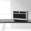 A modern combination microwave oven is displayed on a dark countertop against a white and light gray background. Produktbild-Vorschau