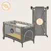 A baby crib/playpen and its folded form are shown against a light beige background. Podgląd zdjęcia produktu