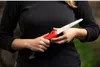 A person holding a folding saw outdoors. Podgląd zdjęcia produktu