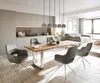 A modern dining room and kitchen area with a dining table and chairs, and a glimpse of a living room in the background. Produktbild-Vorschau