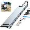 A silver USB-C docking station with multiple ports and cables is displayed against a white background, with a small inset image showing it connected to a laptop and monitors. Produktbild-Vorschau