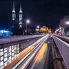 A night-time cityscape with light trails from vehicles and illuminated buildings. Náhľad obrázku produktu