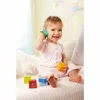 A baby is sitting on a bed and playing with colorful blocks. Podgląd zdjęcia produktu