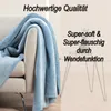 A blue blanket draped over a sofa, with text overlays describing its features. Anteprima dell’immagine prodotto