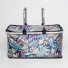 A picnic basket with a floral leaf pattern and silver handles against a white background. Náhled obrázku produktu