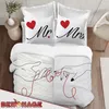 A neatly made bed with Mr. & Mrs. themed bedding. Produktbild-Vorschau