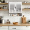 A white slatted wall cabinet with two doors and an open shelf below, mounted on a white subway tile backsplash above a wooden countertop. Various jars and kitchen utensils are visible. Podgląd zdjęcia produktu
