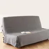 A grey sofa cover is shown on a sofa, with a book placed on it. Produktbild-Vorschau