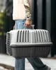 A person is walking outdoors carrying a pet carrier. Anteprima dell’immagine prodotto