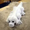 A white crocheted dog toy lying on a furry rug. Podgląd zdjęcia produktu