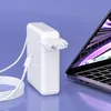 A white laptop charger and cable are placed next to an open laptop on a light purple background. Podgląd zdjęcia produktu