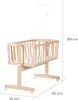 A wooden baby cradle with wheels and a hanging mobile attachment, shown with dimensions indicated. Produktbild-Vorschau