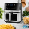 A modern air fryer is displayed prominently on a countertop, with a plate of french fries in the foreground and a basket of fries in the background. Produktbild-Vorschau