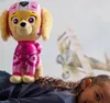 A child is lying down with a plush toy dog on their back, with a drawing of an airplane in the background. Podgląd zdjęcia produktu