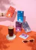 A collection of coffee capsules and a glass of coffee are arranged on a pink and orange surface, with sunglasses in the foreground. Náhľad obrázku produktu