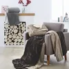 Cozy living room scene with blankets draped over a chair and fireplace. Produktbild-Vorschau
