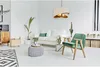 A modern living room with a white sofa, green armchair, plants, and a striking pendant lamp. Produktbild-Vorschau