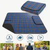 A folded and unfolded picnic blanket with feature icons and lifestyle images below. Produktbild-Vorschau