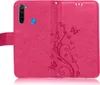 A pink flip case for a smartphone, with embossed floral and butterfly patterns. Produktbild-Vorschau