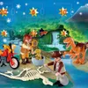 A Playmobil advent calendar scene depicting a dinosaur expedition with figures, dinosaurs, a motorcycle, and a skeleton. Produktbild-Vorschau