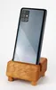 A Samsung smartphone is displayed in a wooden phone stand against a white background. Podgląd zdjęcia produktu