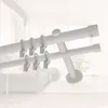 A double curtain rod with rings and clips, set against a blurred interior background. Produktbild-Vorschau