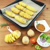 A baking tray with spiral-cut potatoes on skewers, alongside raw potatoes, a spiralizer tool, and a small dish of seasoning. Anteprima dell’immagine prodotto