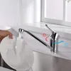 A hand is washing a plate under a faucet in a kitchen sink. Produktbild-Vorschau