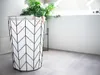 A modern bathroom with a patterned laundry basket and a plant. Produktbild-Vorschau