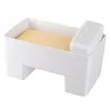 A white butter dish with a yellow block of butter inside and a small white lid on the side. Podgląd zdjęcia produktu