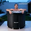 A man is relaxing in an ice bath outdoors at dusk. Náhled obrázku produktu