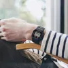 A person wearing a black G-SHOCK watch on their wrist, sitting in a chair. Anteprima dell’immagine prodotto