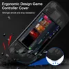 A black protective cover for a game controller is shown on a dark, textured surface, with debris falling around it to illustrate its shock resistance. Produktbild-Vorschau