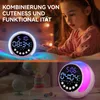 A split image showing a digital alarm clock with RGB night light in two different settings. The top half shows a young girl looking at a tablet next to the clock, with text overlay. The bottom half shows the clock on a nightstand with other children's toys Produktbild-Vorschau