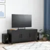A black TV stand with a television on top, placed in a room with a rug and a plant. Anteprima dell’immagine prodotto