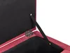 A close-up view of the interior of a red fabric storage ottoman, showing the hinge and a strap mechanism. Náhled obrázku produktu